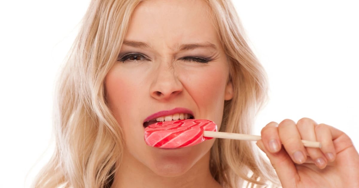woman eating lollypop, concept of a cracked tooth