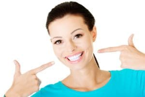 woman pointing to teeth, concept of What causes chipped teeth and what are the treatment options?