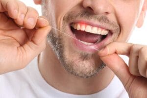 man flossing his teeth