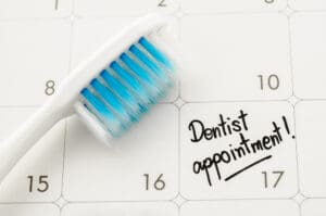 Calendar with tooth brush and writing to chedule Your 2024 Dental Appointment