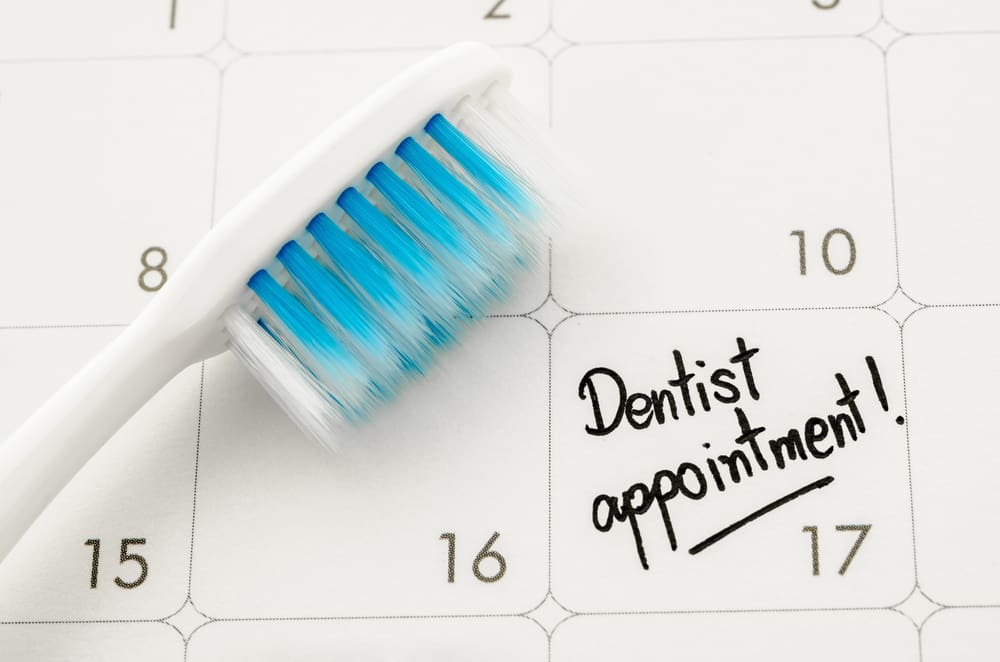 Calendar with tooth brush and writing to chedule Your 2024 Dental Appointment