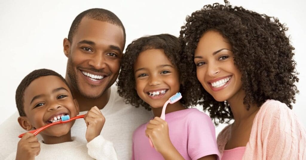 African American family brushing their teeth, concept of oral care steps to promote better dental health with fluoride