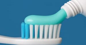 toothpaste going on toothbrush, concept of current 2025 public health fluoride guidelines and concerns
